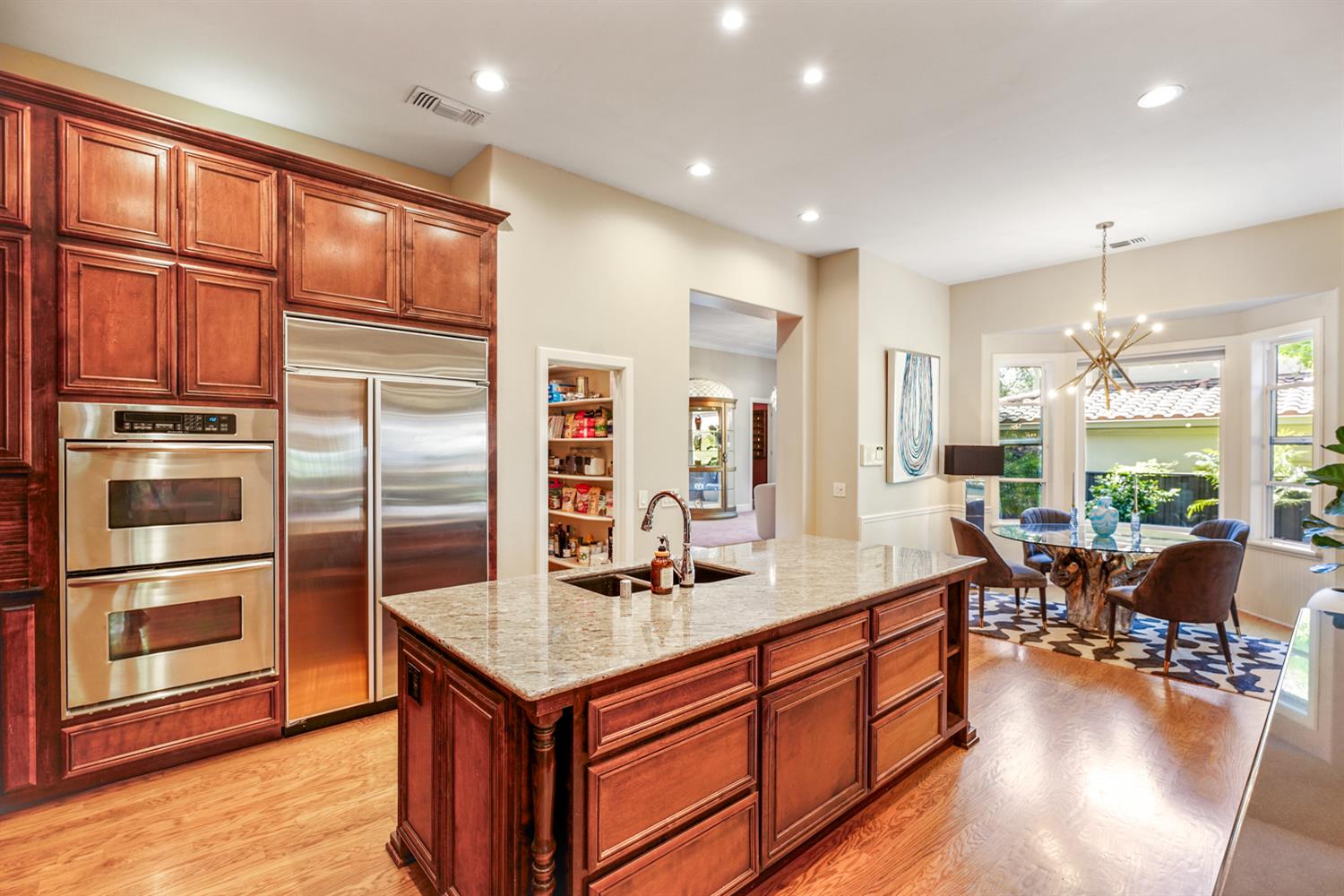 5512 Riviera Granite Bay, CA 95746 - Photo 21 of 76 a kitchen with stainless steel appliances granite countertop a refrigerator a stove and a wooden floors