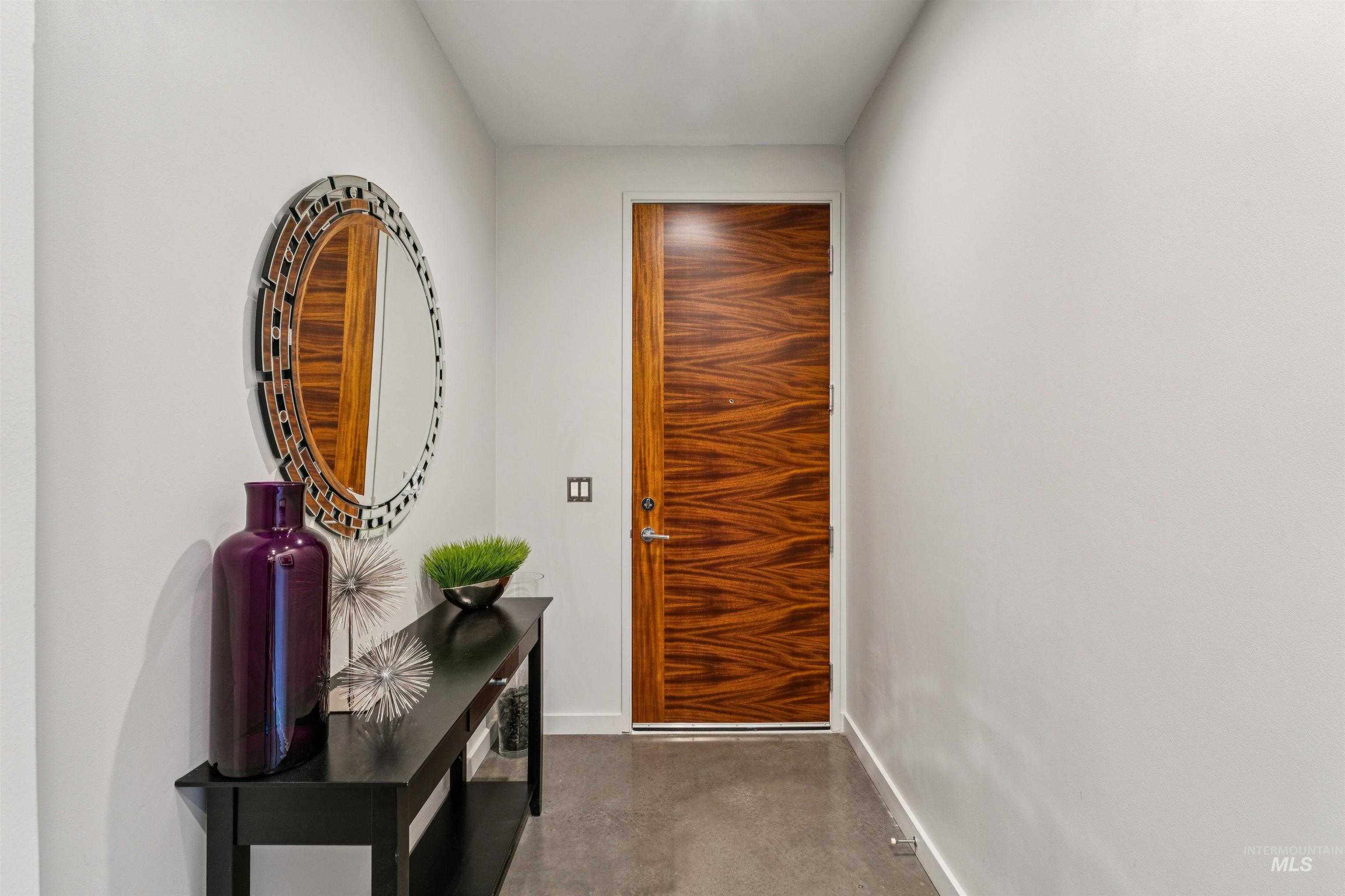 119 South 10th Street, Unit 307 Boise, ID 83702 - Photo 35 of 47 Entryway featuring a wood-panel door, concrete-finish flooring, and white walls