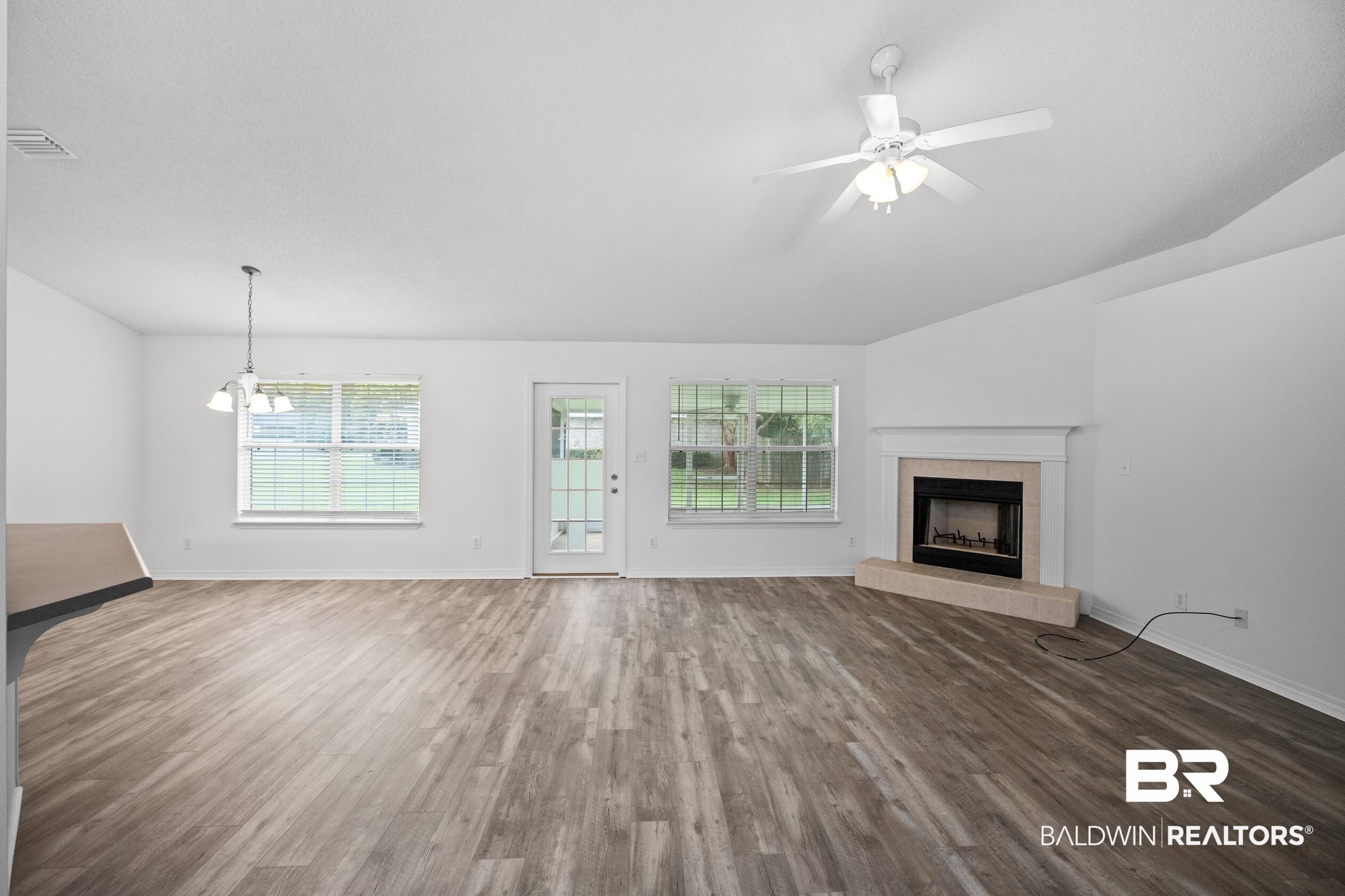306 Monteith Oaks Drive Foley, AL 36535 - Photo 2 of 38 Unfurnished living room with wood finished floors, a tile fireplace, and a ceiling fan