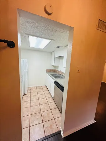 a kitchen with a sink a stove top oven and white cabinets