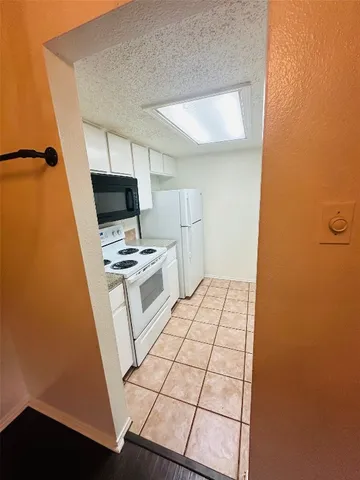 a kitchen with white cabinets and appliances