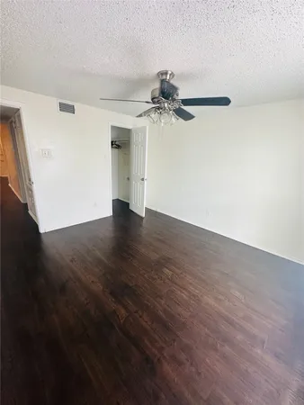 a view of a big room with wooden floor and windows