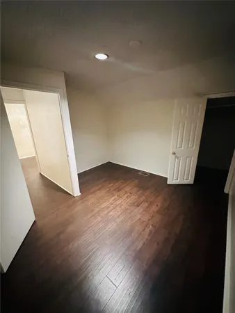an empty room with wooden floor and door