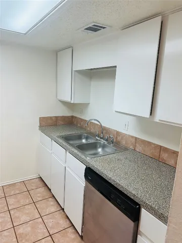 a kitchen with granite countertop a sink and a stove