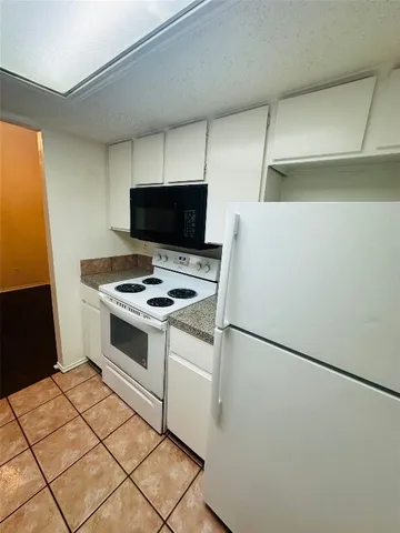 a white refrigerator freezer and a stove sitting inside of a kitchen