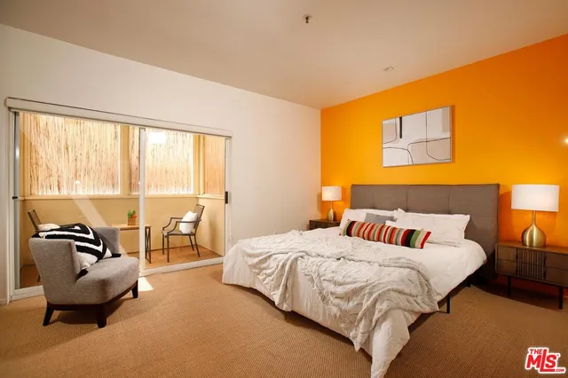 a bedroom with a bed a couch and dresser