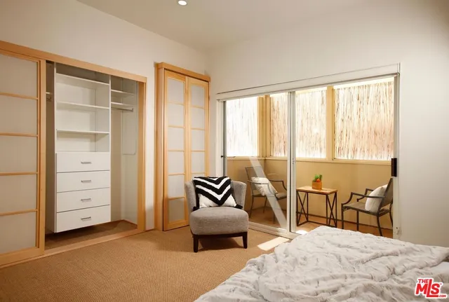 a bedroom with furniture and large windows