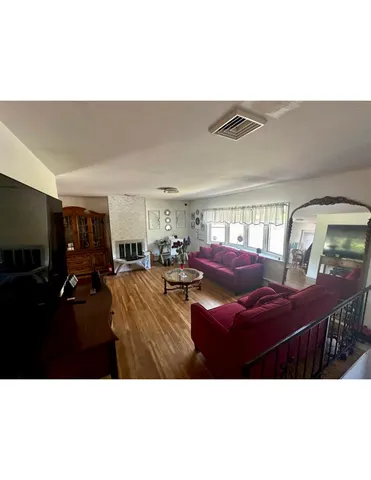 a open kitchen with stainless steel appliances kitchen island granite countertop a sink dishwasher and a refrigerator with wooden floor