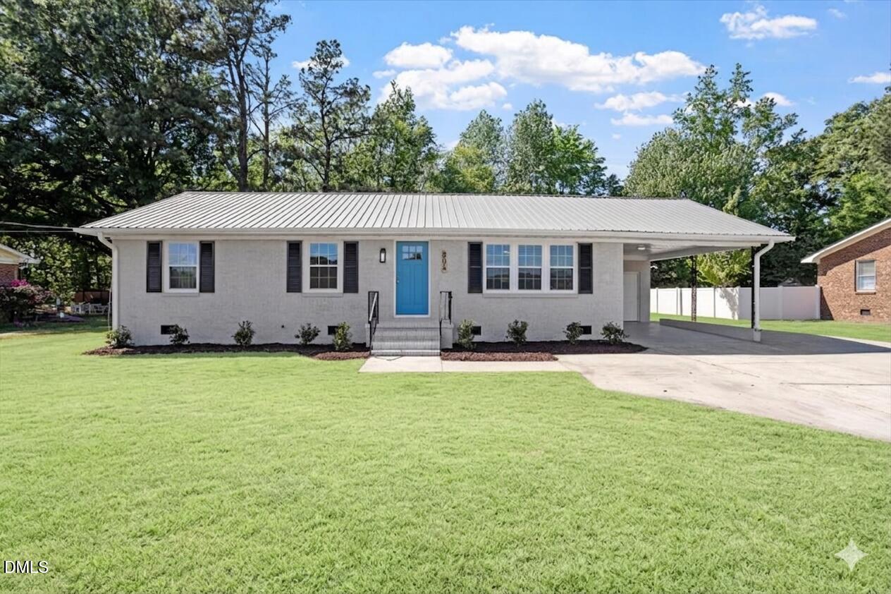 a view of a house with a backyard and a tree
