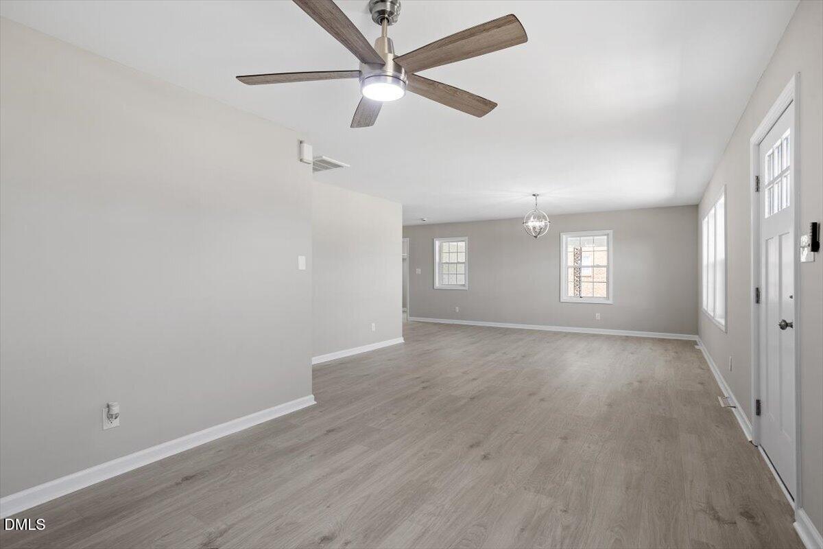 804 Little Rock Church Road Lucama, NC 27851 - Photo 12 of 28 an empty room with wooden floor fan and windows