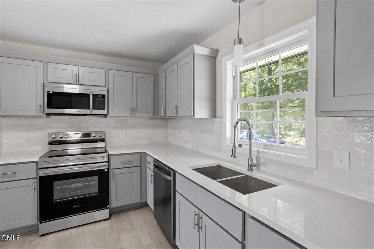 804 Little Rock Church Road Lucama, NC 27851 - Photo 2 of 28 a kitchen with a stove a sink and a microwave