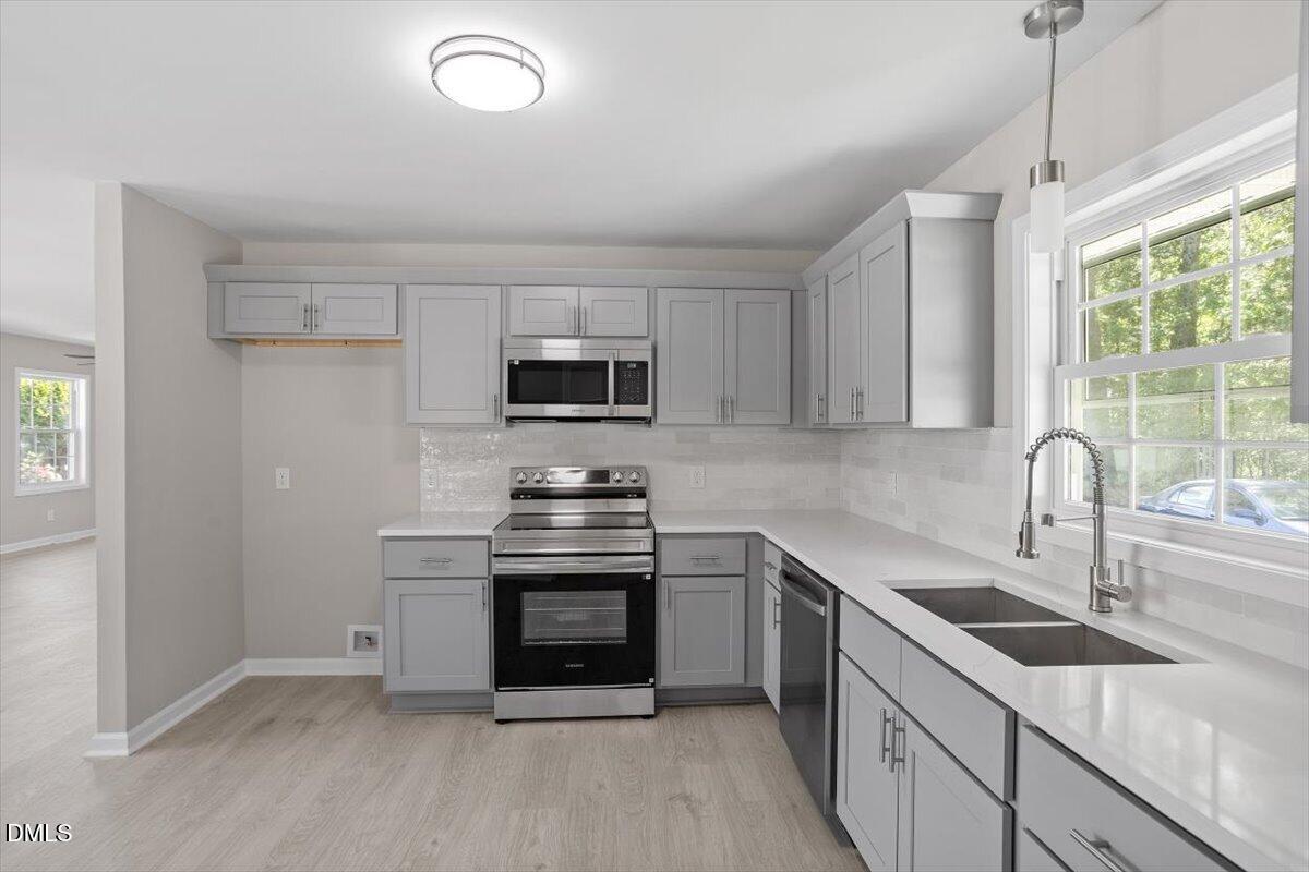 804 Little Rock Church Road Lucama, NC 27851 - Photo 4 of 28 a kitchen with stainless steel appliances granite countertop a sink a stove a refrigerator cabinets and a window