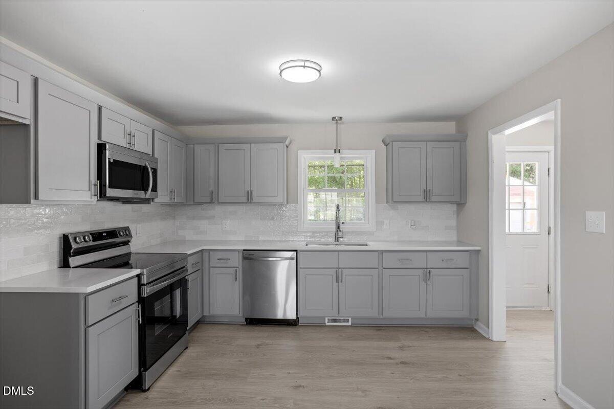 804 Little Rock Church Road Lucama, NC 27851 - Photo 7 of 28 a kitchen with stainless steel appliances a sink stove and microwave
