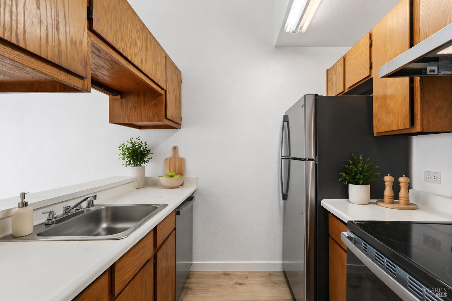a kitchen with stainless steel appliances granite countertop a sink and a refrigerator