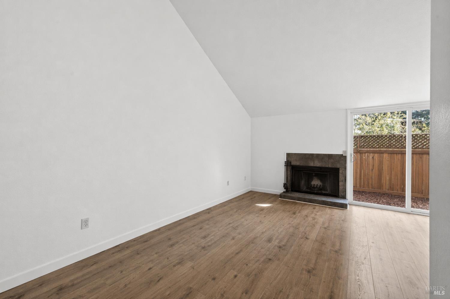 230 Courtyards East Windsor, CA 95492 - Photo 16 of 47 a view of an empty room with wooden floor fireplace and a window
