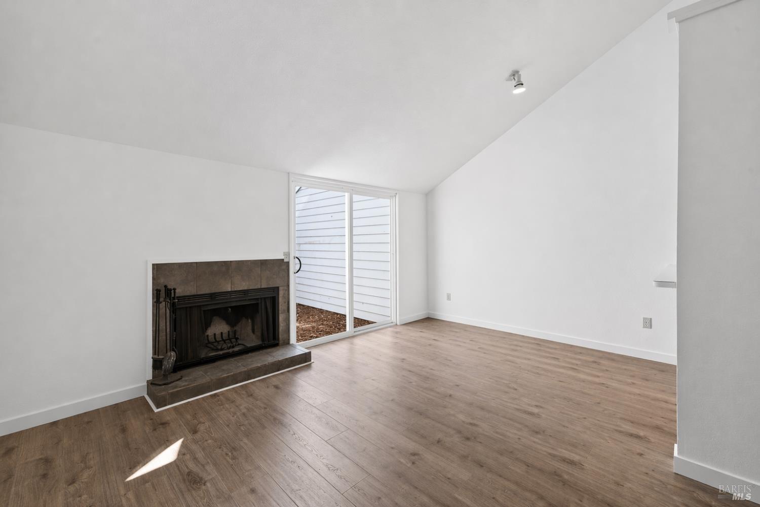 230 Courtyards East Windsor, CA 95492 - Photo 18 of 47 a view of an empty room with wooden floor fireplace and a window