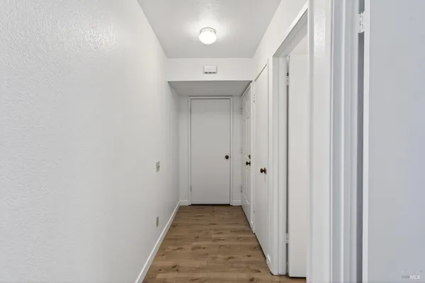 a view of a hallway with wooden floor
