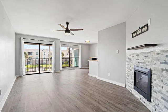 a view of a livingroom with a fireplace and a ceiling fan