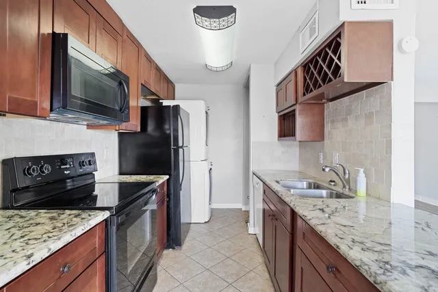 a kitchen with granite countertop a sink and a stove
