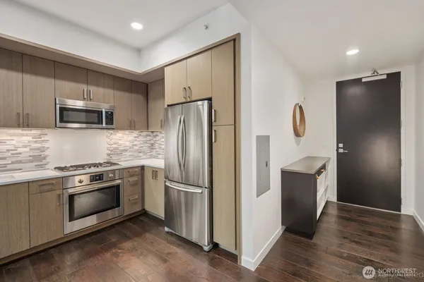 a kitchen with stainless steel appliances granite countertop a refrigerator and a stove top oven
