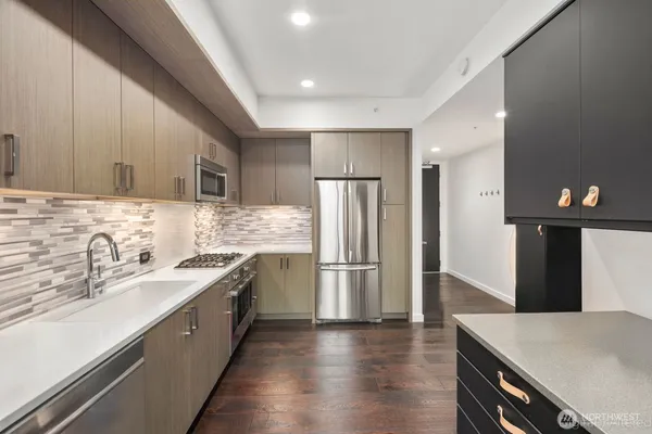 a kitchen with a sink a refrigerator and cabinets