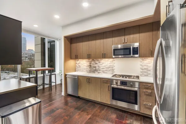 a kitchen with kitchen island granite countertop a stove and a refrigerator
