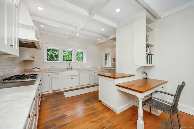 a kitchen with granite countertop a stove a sink and a refrigerator