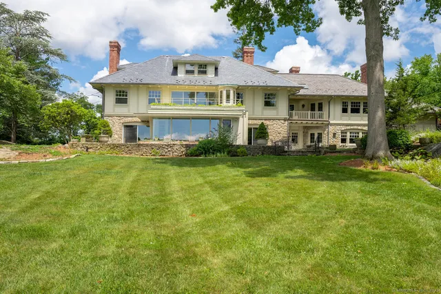 a view of a house with a big yard and potted plants