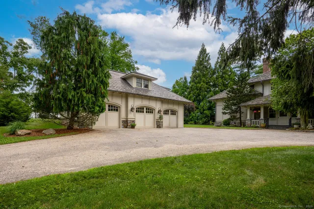 a front view of a house with a garden and trees