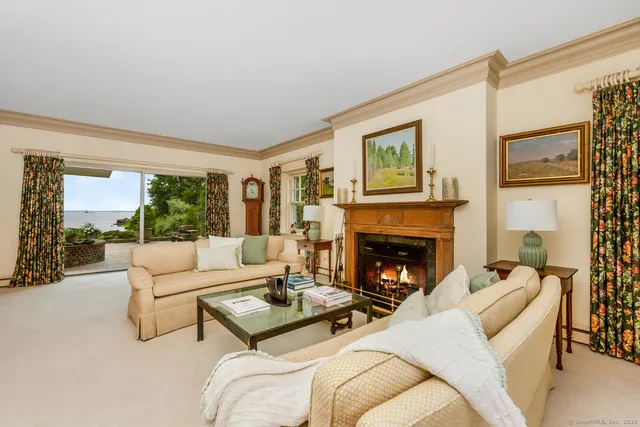 a living room with furniture fireplace and a large window