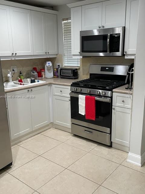 6705 North Kendall Drive, Unit 305 Pinecrest, FL 33156 - Photo 2 of 11 a kitchen with stainless steel appliances granite countertop a stove a microwave and a sink