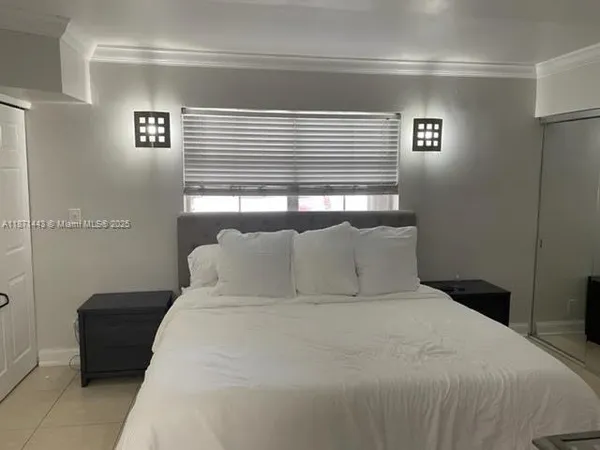 a large bed sitting in a bedroom next to a window