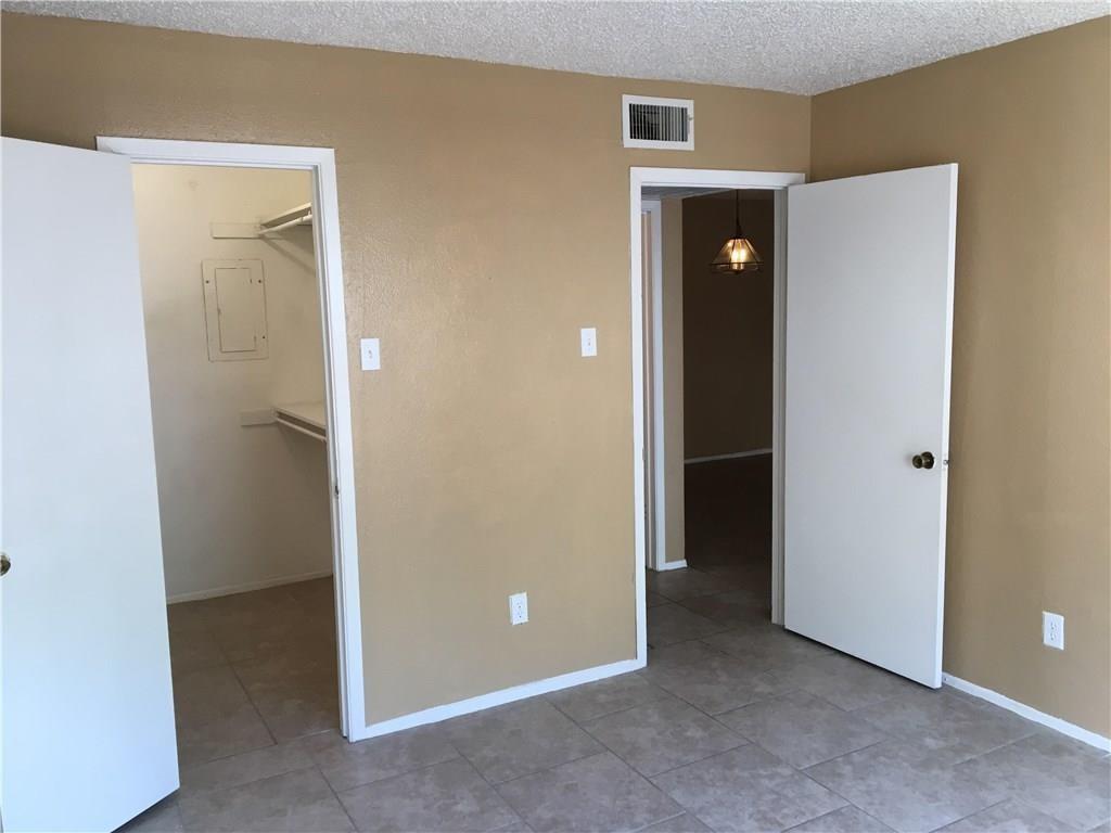 8110 Skillman Street, Unit 2020 Dallas, TX 75231 - Photo 10 of 12 Unfurnished bedroom featuring a spacious closet, a textured ceiling, light tile patterned flooring, and electric panel