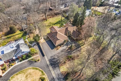 an aerial view of a house with swimming pool and green space