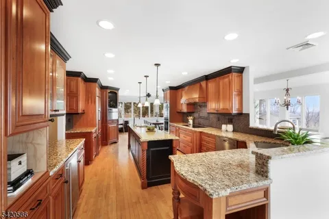 a kitchen with stainless steel appliances granite countertop sink stove refrigerator and cabinets