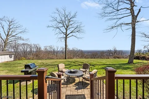 a view of a lake with a table and chairs under an umbrella