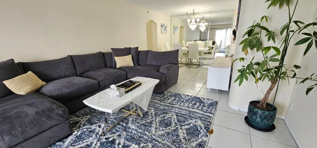 a living room with furniture and a potted plant