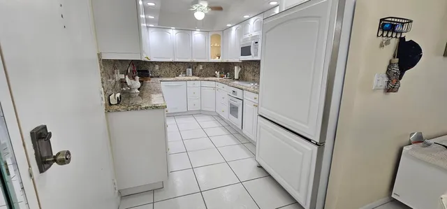 a kitchen with white cabinets and white appliances