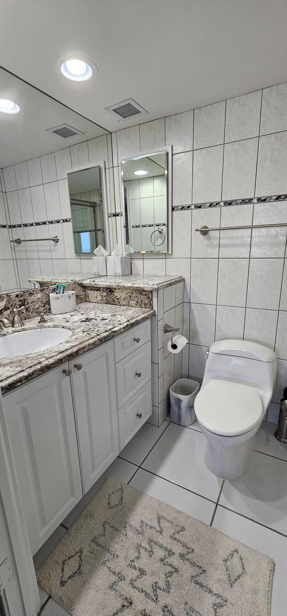 3215 South Ocean Boulevard, Unit 1010 Highland Beach, FL 33487 - Photo 9 of 23 a bathroom with a toilet sink and mirror