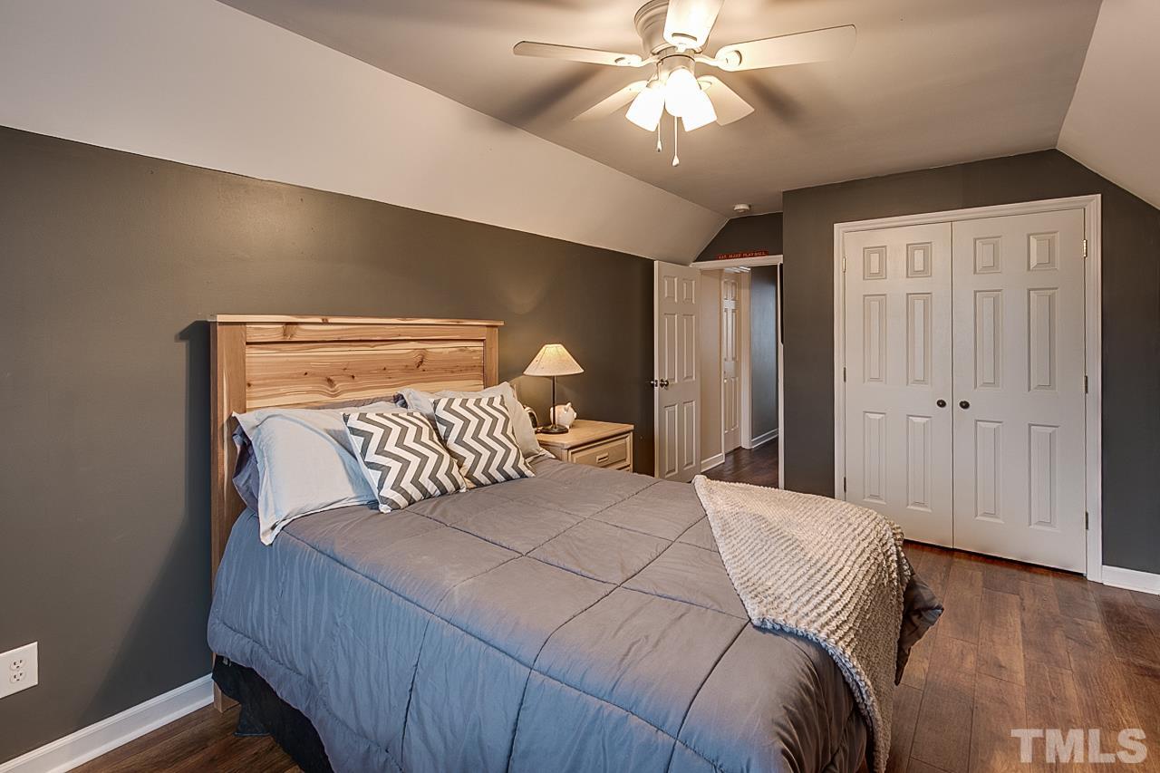 306 Charlie S Road Robbins, NC 27325 - Photo 17 of 30 a bedroom with a large bed and a chandelier