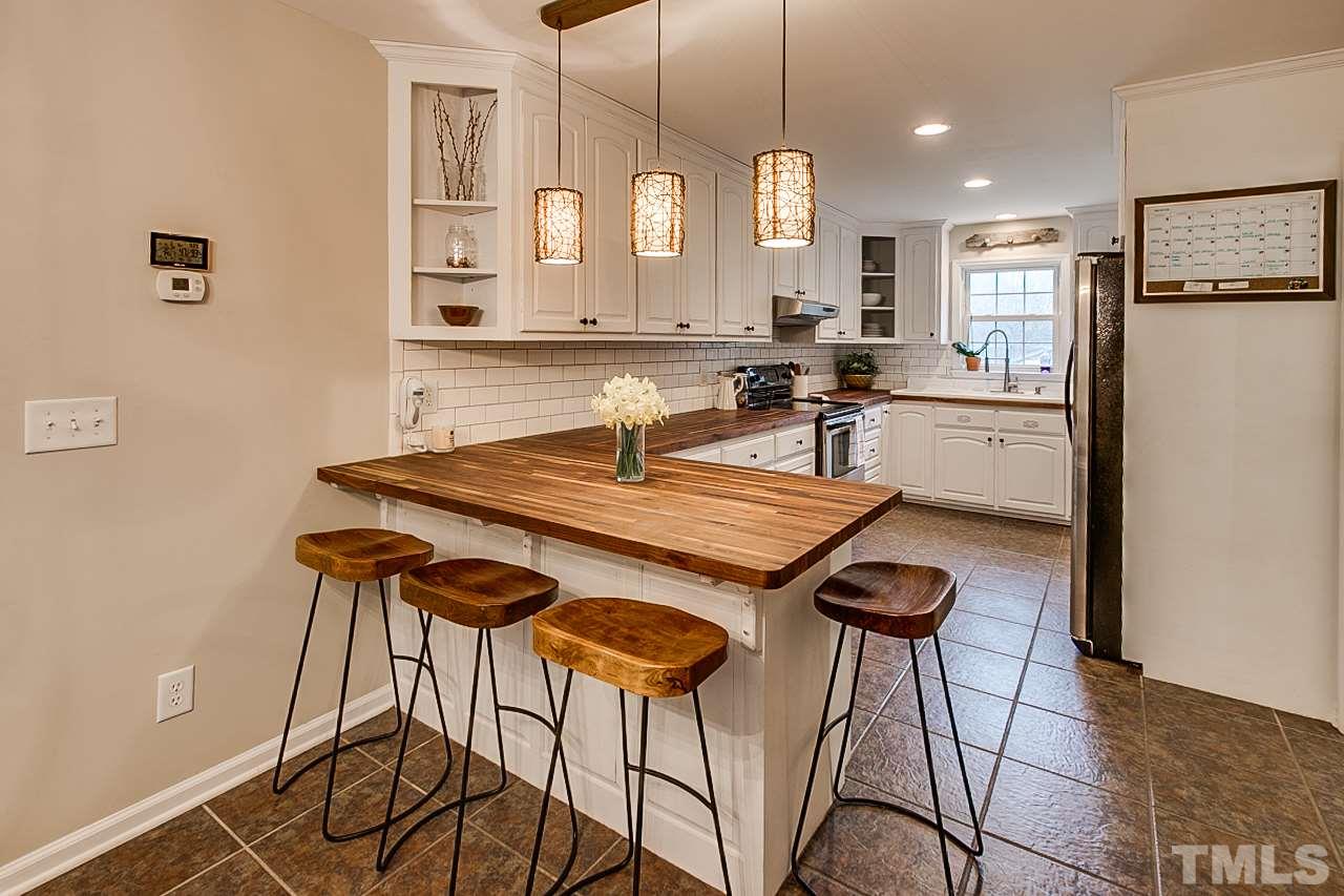 306 Charlie S Road Robbins, NC 27325 - Photo 6 of 30 a kitchen with stainless steel appliances kitchen island a table and chairs in it