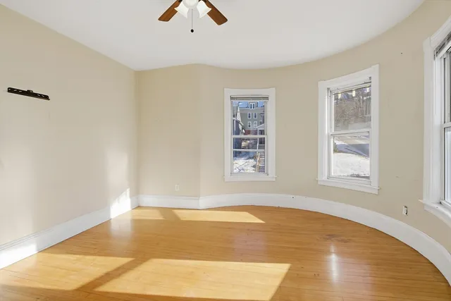 a view of a room with wooden floor and window