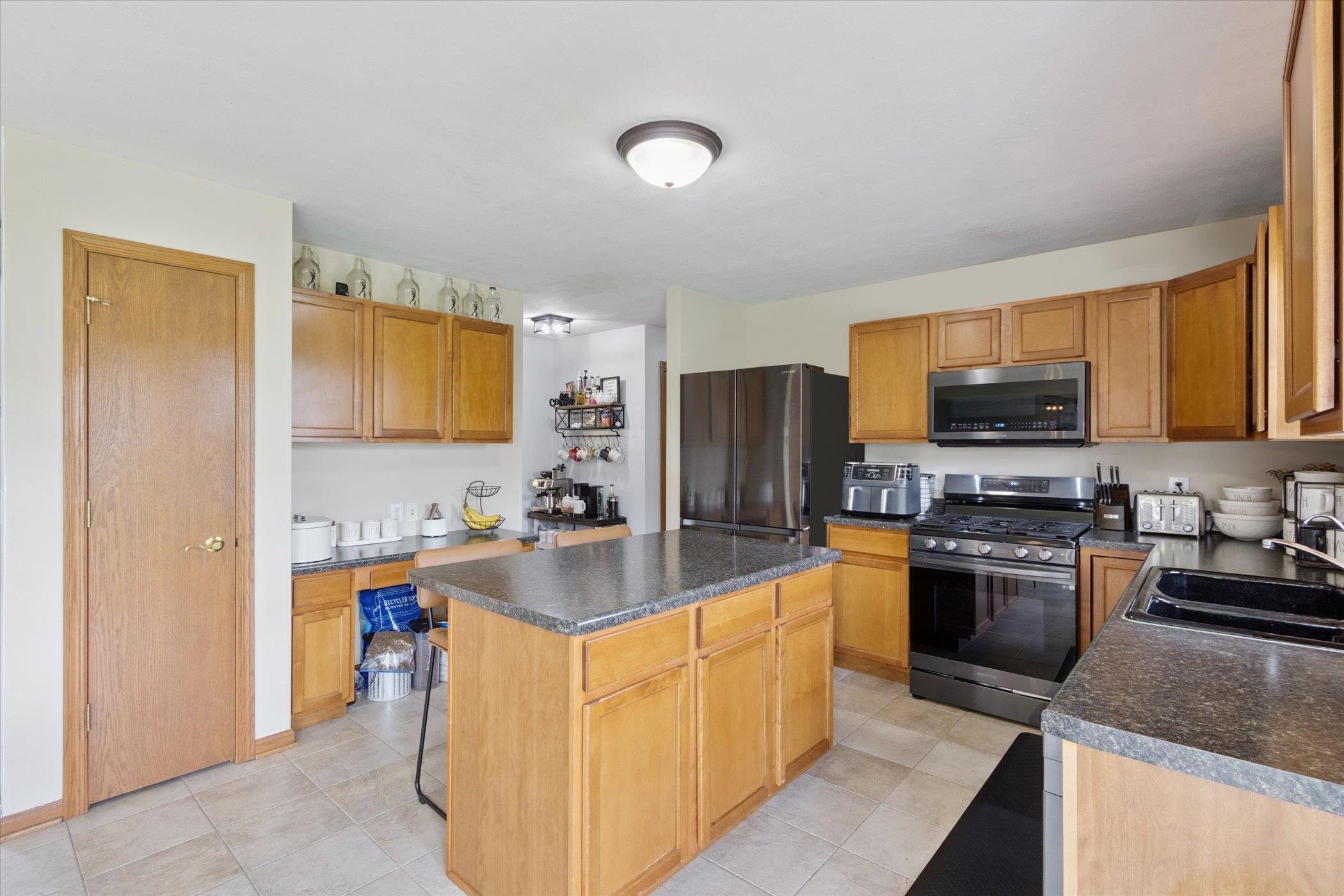 1442 Rock Island Road Davis Junction, IL 61020 - Photo 21 of 63 a kitchen with stainless steel appliances granite countertop a sink stove and refrigerator
