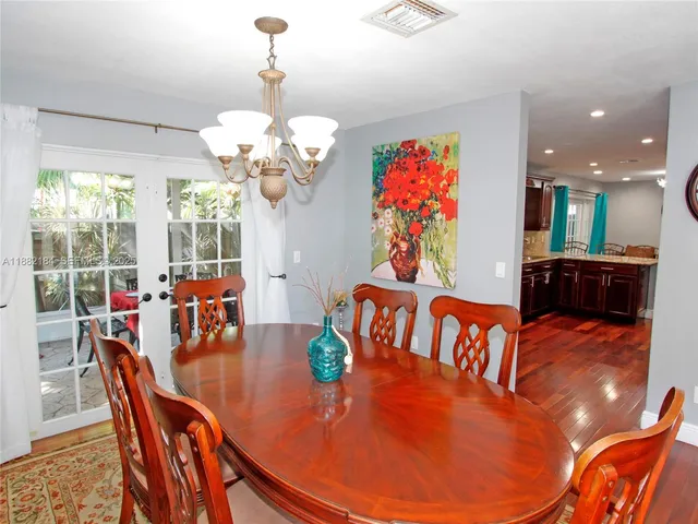 a view of a dining room with furniture a chandelier and wooden floor
