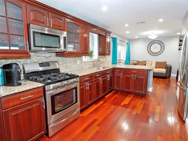 a kitchen with stainless steel appliances a stove a sink and a microwave