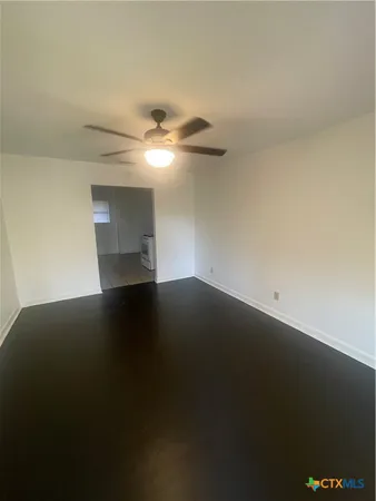 an empty room with a ceiling fan and a window