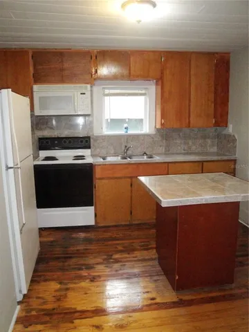 a kitchen with stainless steel appliances granite countertop a sink stove and microwave