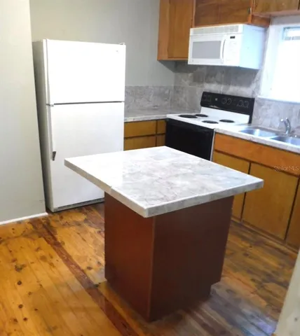 a kitchen with a sink cabinets and wooden floor