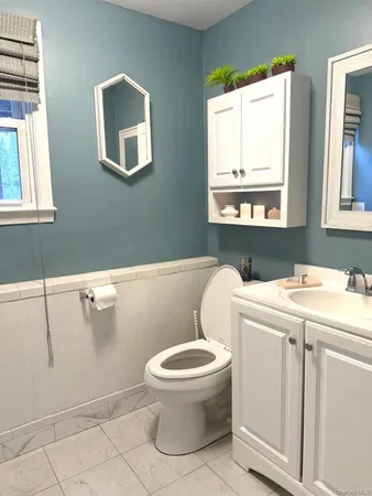 a bathroom with a sink a toilet and a window