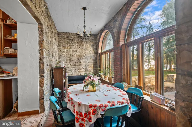 a dining room with furniture a chandelier and wooden floor
